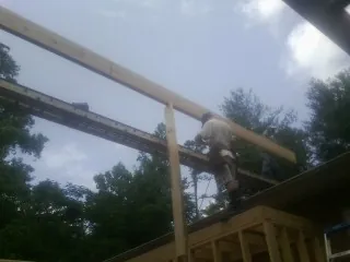 Carpenter setting a ridge beam over a new addition frame — Ice Dam Removal by Roofing Brothers in Rotterdam Junction