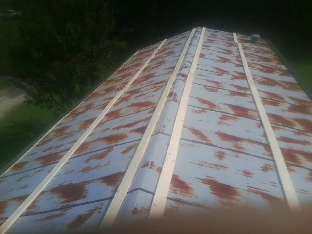 Rusted metal roof panels with new wood purlins before replacement — Storm Damage Roof Repair in Rotterdam Junction by Roofing Brothers