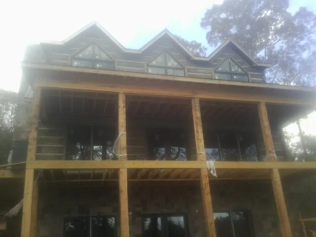 Dormers and porch framing on a large log home under construction — Roof Coating work by our crew in Rotterdam Junction