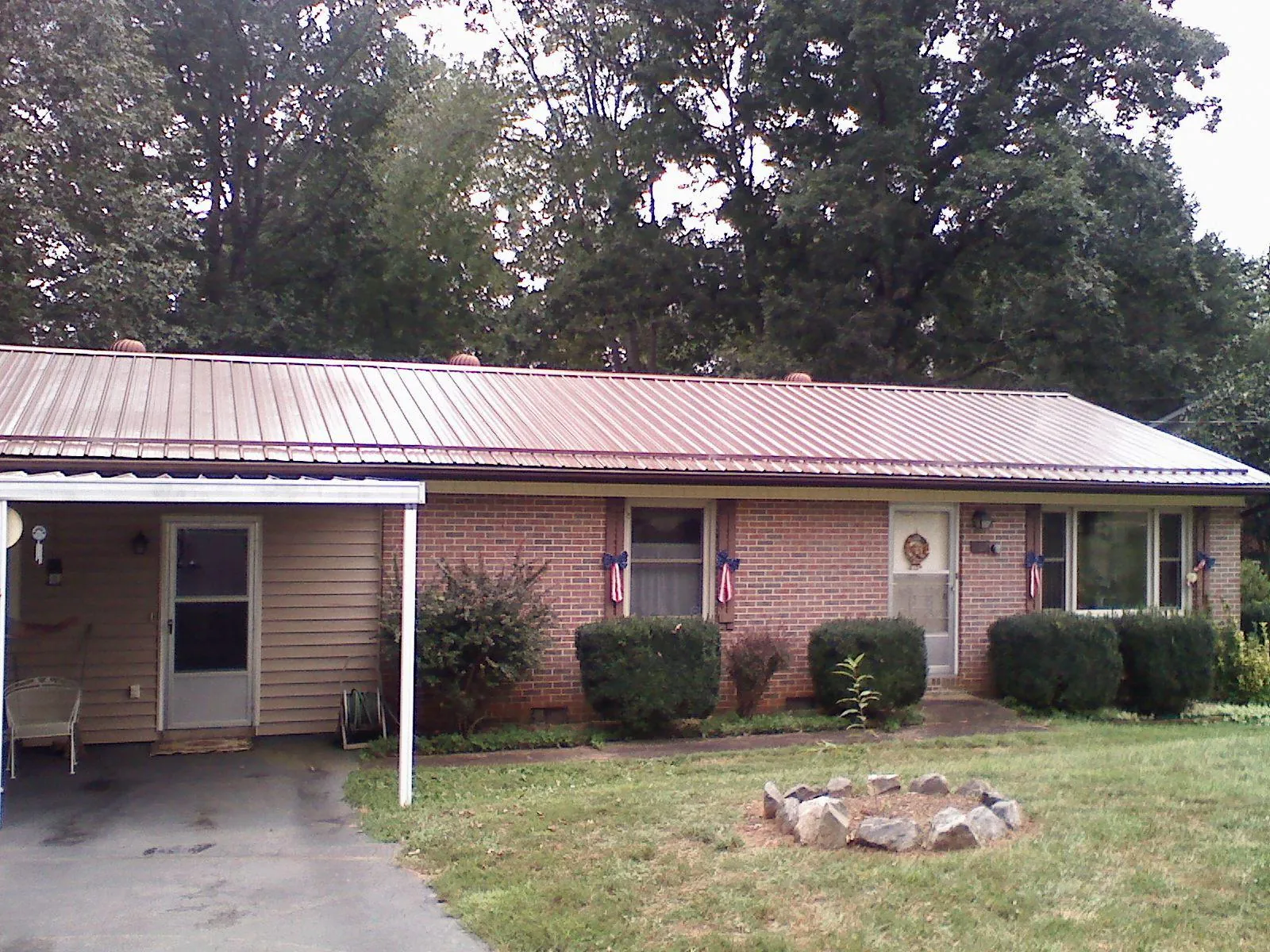 Bronze metal roof and carport on a brick ranch home — Roof Repair work by our crew in Rotterdam Junction
